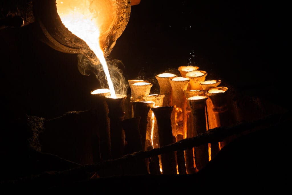 Industrial lost wax casting. The process of pouring for filling out ceramic shells with molten steel from ladle.